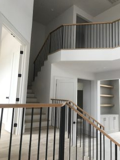 Modern Staircase with White Oak Over-Post Handrail and Satin Black Metal Balusters